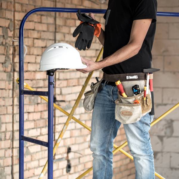 Builder handyman with construction tools. House and house renovation concept background.